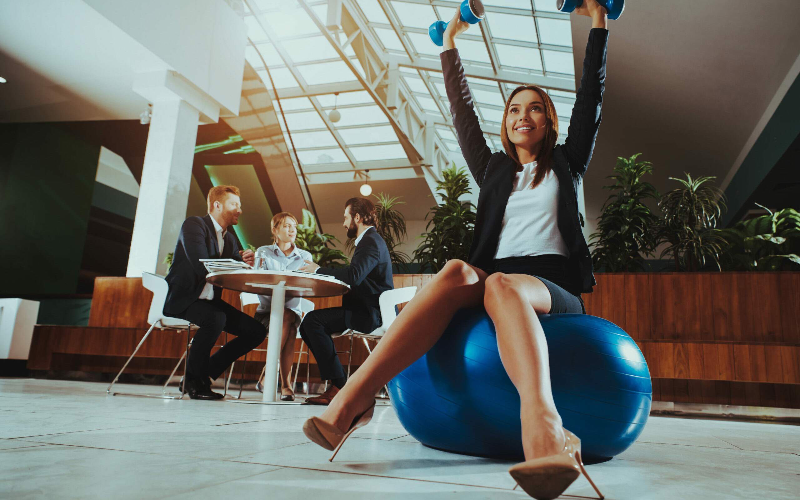 Woman Balance on Ball with Dumbbells in Office