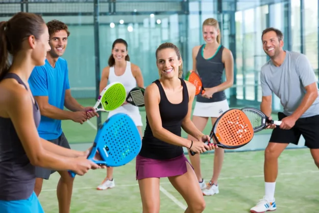 Équipe d'entreprise jouant au padel en salle
