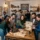 Groupe souriant en atelier d’énigmes, chacun cherche des indices autour d’une table avec cartes et outils, dans une ambiance esprit team building entreprise.