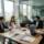 Groupe de professionnels en réunion autour d'une table, brainstorm et documents, calculs et ordinateurs portables, dans une salle de conférence moderne. comment organiser un voyage d'entreprise intégré.