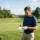 Joueur de golf notant son score sur le parcours, près du green et du drapeau 16, en plein fairway. Règles et formats de compétition golf.