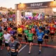 Marathon inter-entreprises Angers 2026: départ en vue avec de nombreux coureurs au ligne de départ et spectateurs, affiche "DÉPART" et ambiance festive.