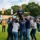 Groupe de colleagues formant une pyramide pour élever une participante lors d’un événement d’entreprise en plein air.