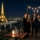 Groupe de convives élégants sur une terrasse parisienne nocturne, avec la Tour Eiffel illuminée en arrière-plan, dégustant des boissons lors d’un événement luxe paris.