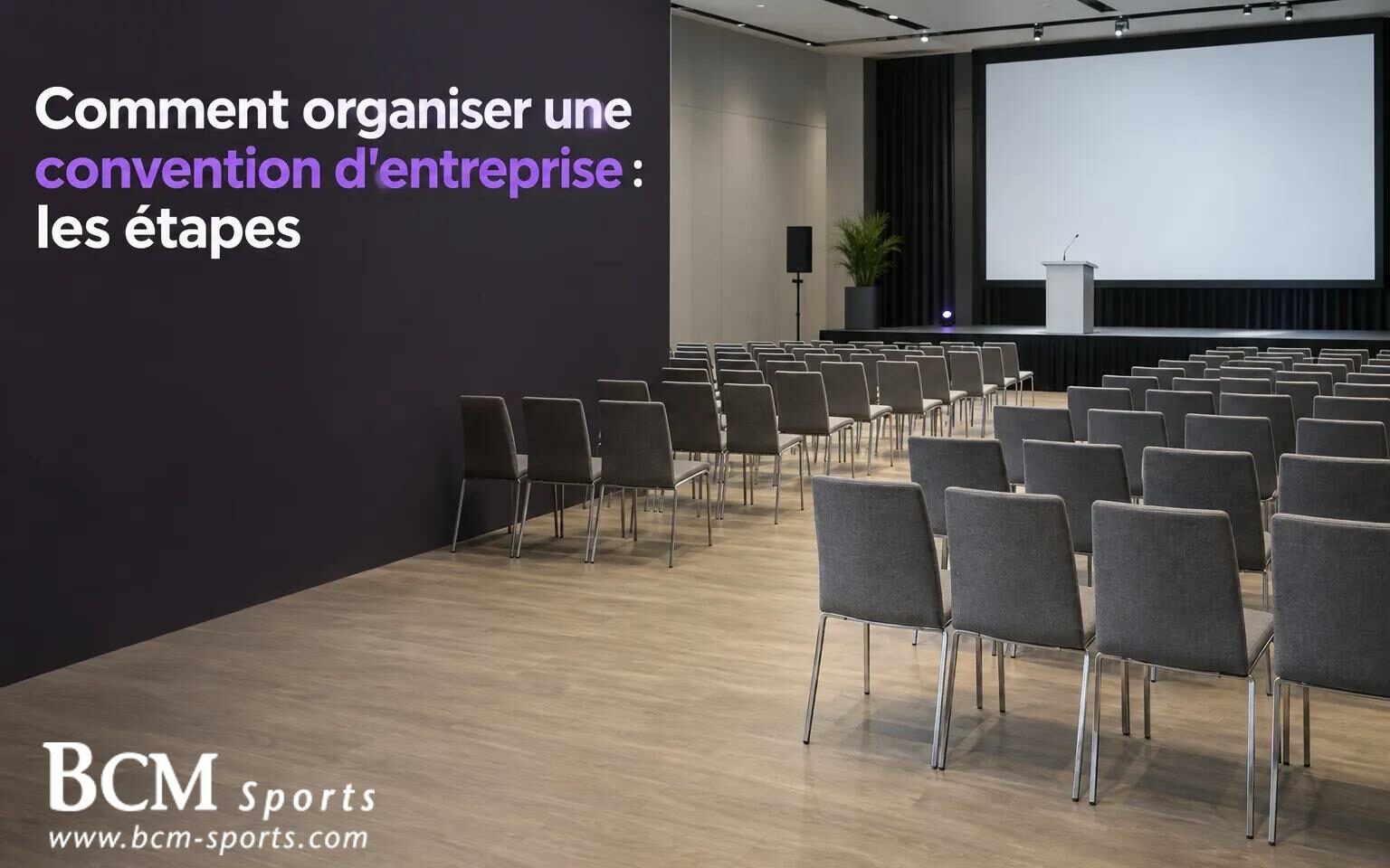 Salle de conférence vide avec un écran et une scène, et un mur noir affichant le titre "Comment organiser une convention