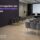 Salle de conférence vide avec un écran et une scène, et un mur noir affichant le titre "Comment organiser une convention
